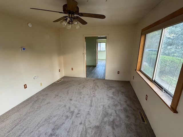 unfurnished room featuring carpet, plenty of natural light, and ceiling fan