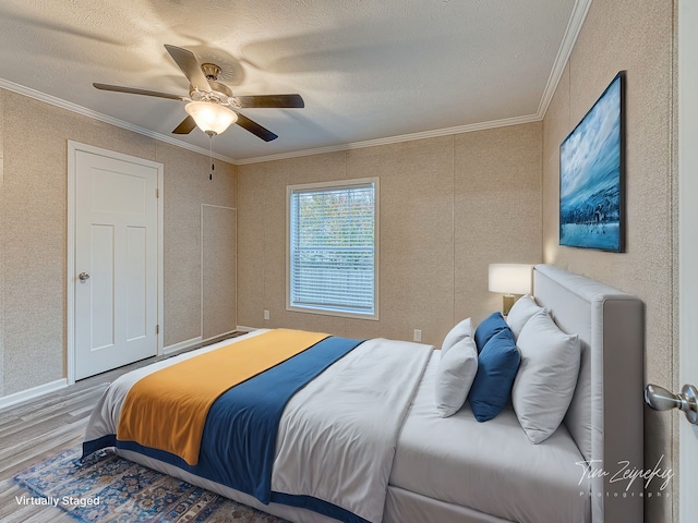 bedroom with wood-type flooring, a textured ceiling, ceiling fan, and ornamental molding