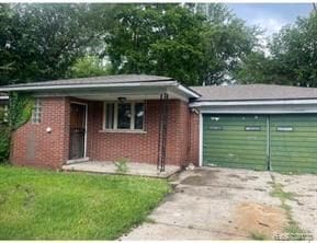 bungalow-style home with a garage and a front lawn