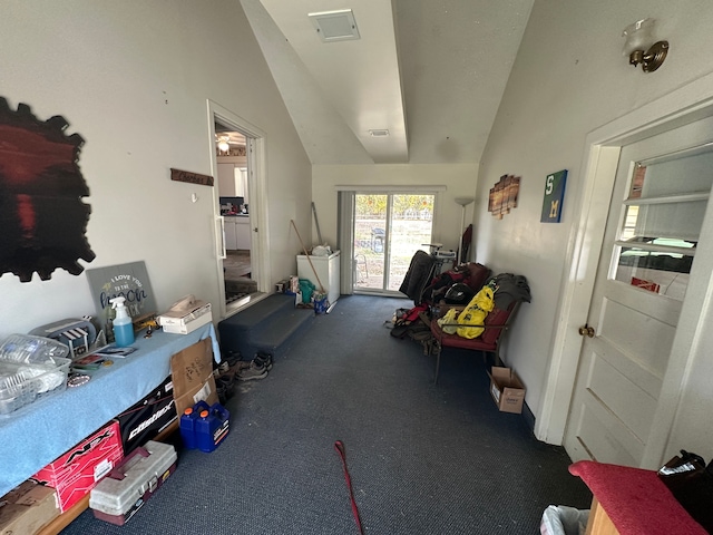 interior space with dark colored carpet and lofted ceiling