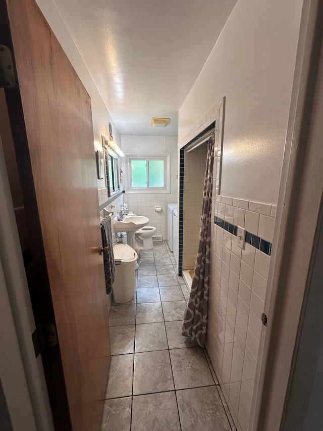 bathroom featuring a bidet, tile patterned flooring, a shower with shower curtain, toilet, and tile walls