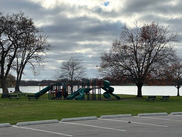 view of jungle gym with a yard and a water view