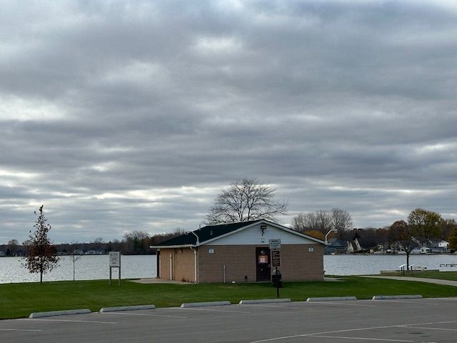 view of sport court with a water view and a yard