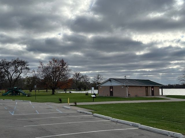 view of vehicle parking with a yard and a playground