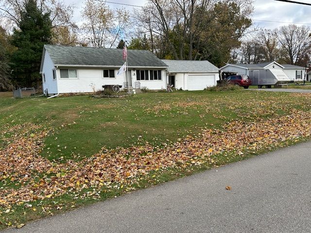 ranch-style house with a garage and a front lawn