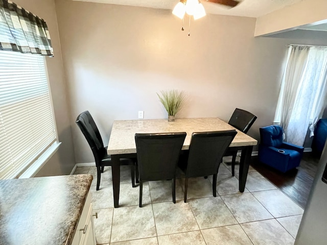 tiled dining space with ceiling fan