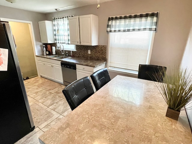 kitchen with white cabinets, sink, light tile patterned floors, appliances with stainless steel finishes, and tasteful backsplash