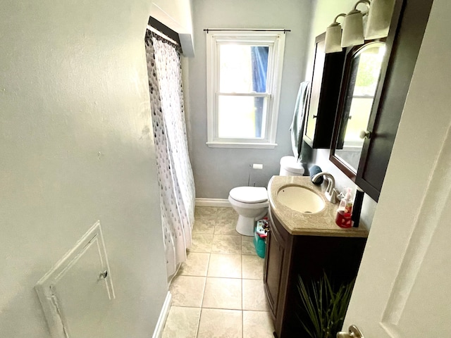 bathroom featuring tile patterned flooring, vanity, toilet, and walk in shower