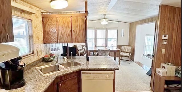 kitchen with white dishwasher, plenty of natural light, lofted ceiling, and light carpet