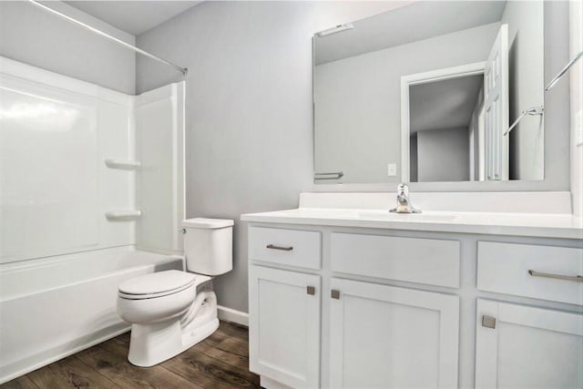 full bathroom with hardwood / wood-style floors, vanity, shower / bathtub combination, and toilet