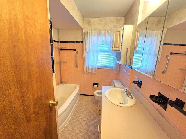 bathroom featuring vanity, toilet, and tile walls