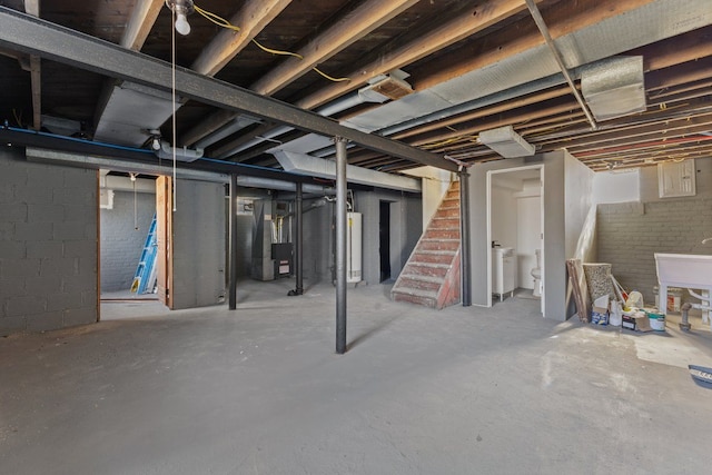 basement featuring gas water heater, washer / clothes dryer, and heating unit