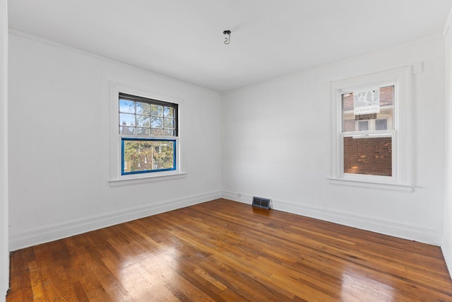 spare room featuring wood-type flooring and ornamental molding