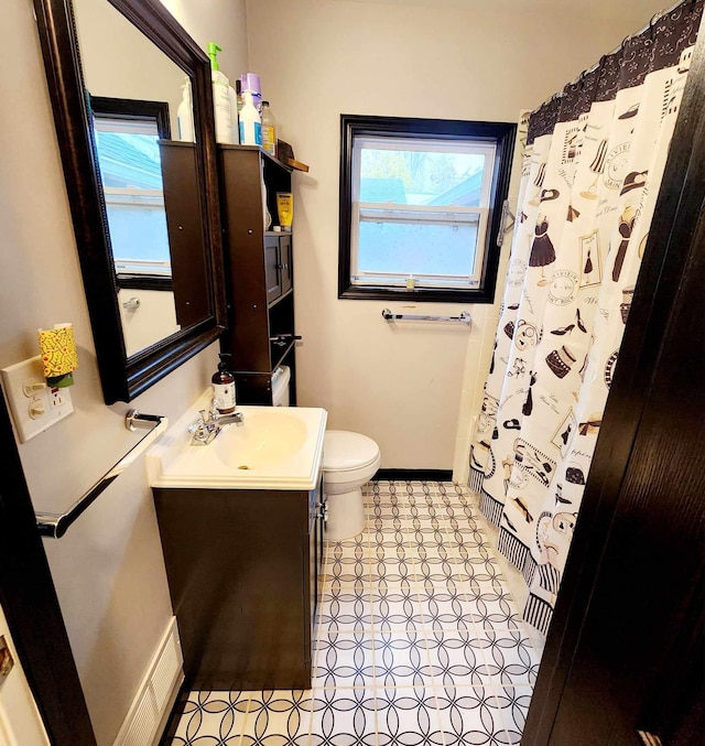 bathroom featuring vanity, curtained shower, and toilet