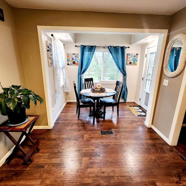 dining space with dark hardwood / wood-style flooring