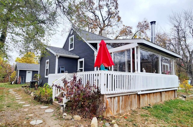 rear view of property with a wooden deck and a sunroom