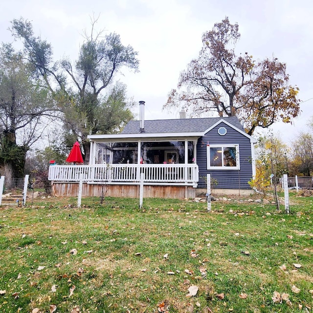 view of front of home with a deck and a front lawn