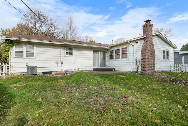 back of property featuring a yard and central air condition unit