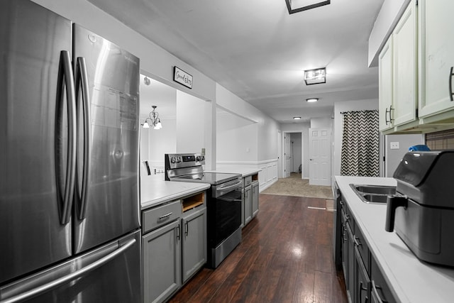 kitchen with stainless steel appliances, dark hardwood / wood-style floors, a notable chandelier, and sink