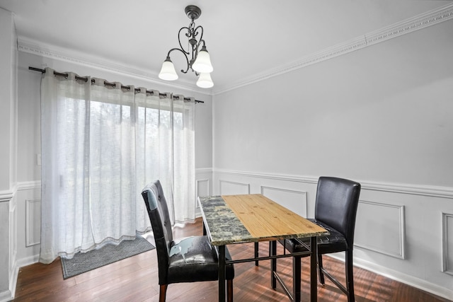 dining area with crown molding, hardwood / wood-style floors, and a chandelier