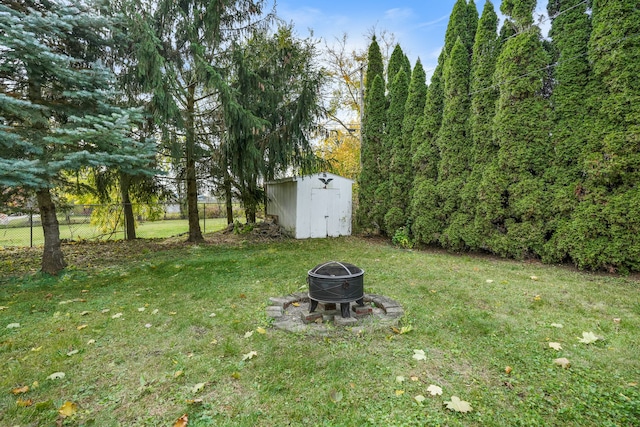 view of yard with a shed and a fire pit