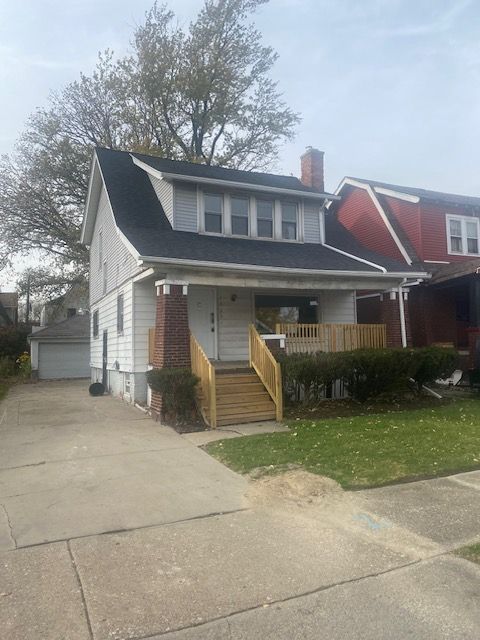 view of front of home featuring a garage, a front lawn, and an outdoor structure