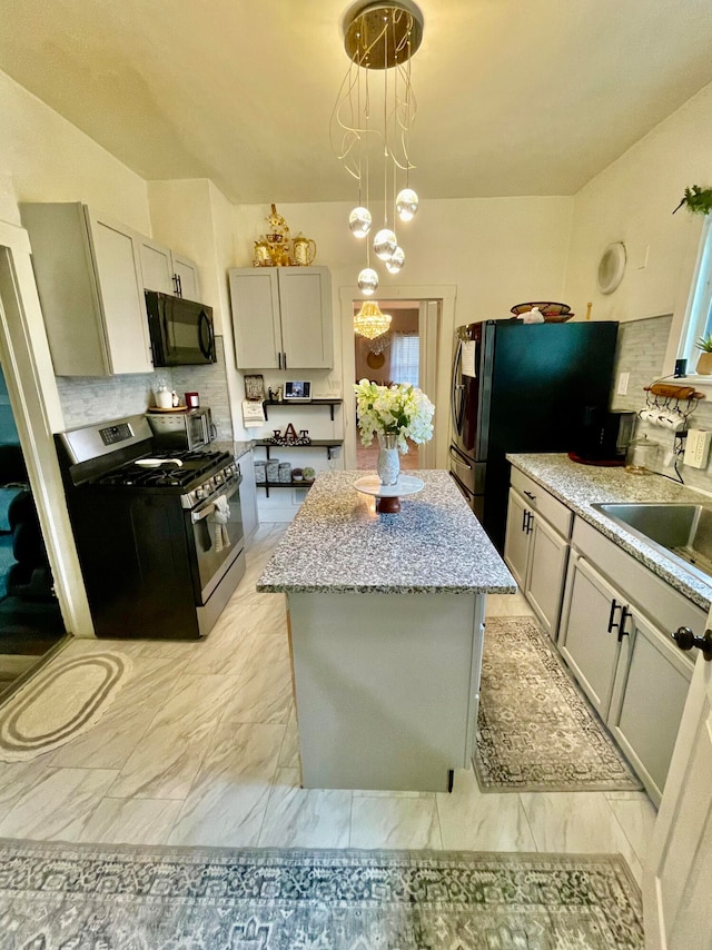 kitchen featuring sink, black appliances, an inviting chandelier, gray cabinets, and hanging light fixtures