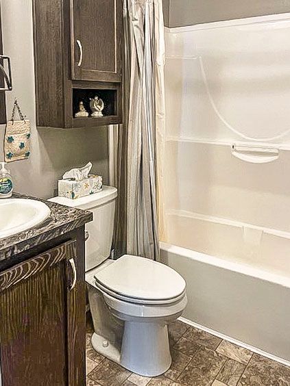 full bathroom with vanity, shower / bath combo, and toilet