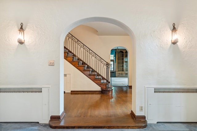 staircase with wood-type flooring and radiator