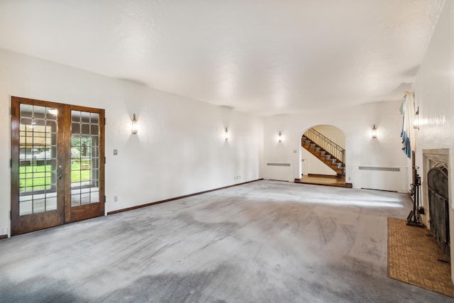 unfurnished living room featuring french doors and light colored carpet