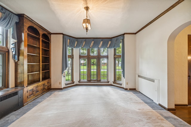 interior space with radiator, carpet floors, and ornamental molding