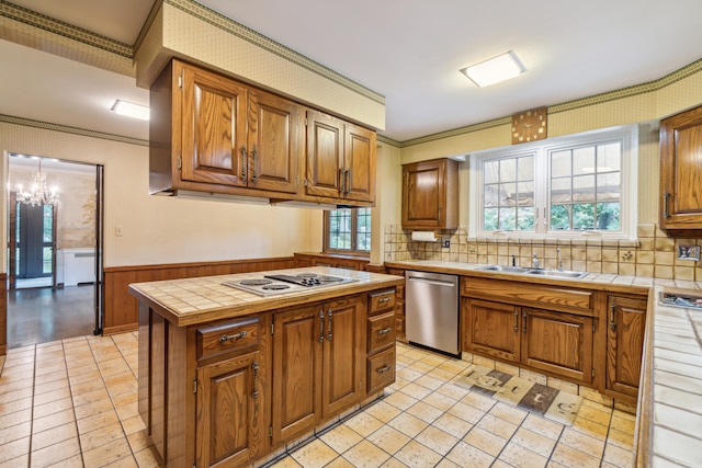 kitchen featuring dishwasher, tile counters, sink, white gas cooktop, and a kitchen island