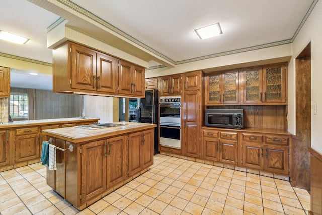 kitchen featuring tile countertops, a kitchen island, crown molding, and black appliances