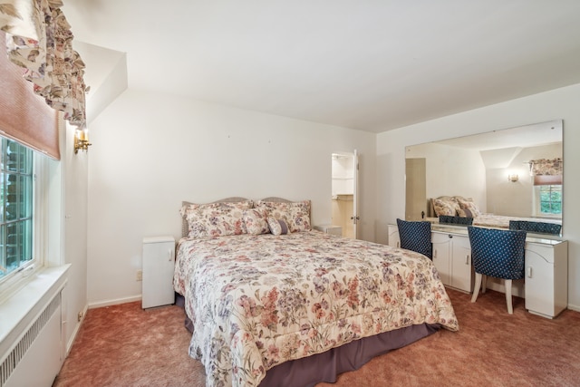 carpeted bedroom featuring radiator heating unit and vaulted ceiling