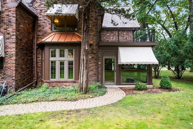 exterior space with a balcony and a lawn