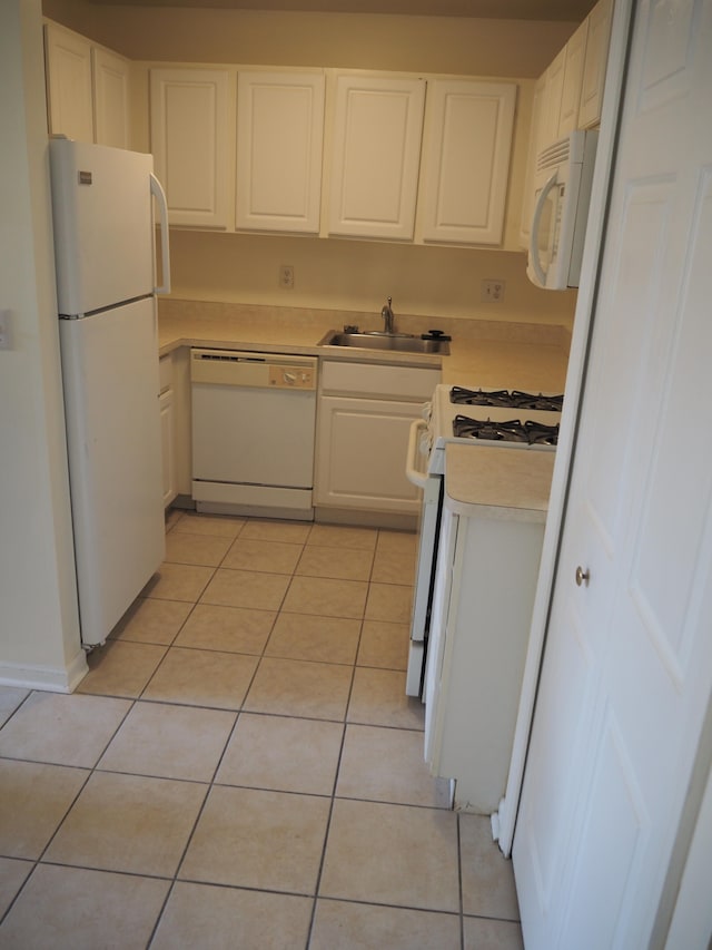 kitchen featuring light tile patterned flooring, white appliances, sink, and white cabinetry