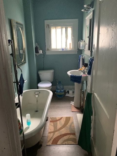 124 W Flint Park Blvd, Flint, MI 48505 - bathroom with a freestanding bath, wood finished floors, and a sink