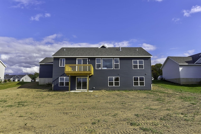 back of property featuring a lawn and a balcony