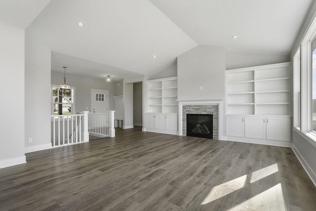 unfurnished living room featuring dark hardwood / wood-style floors, a stone fireplace, and vaulted ceiling