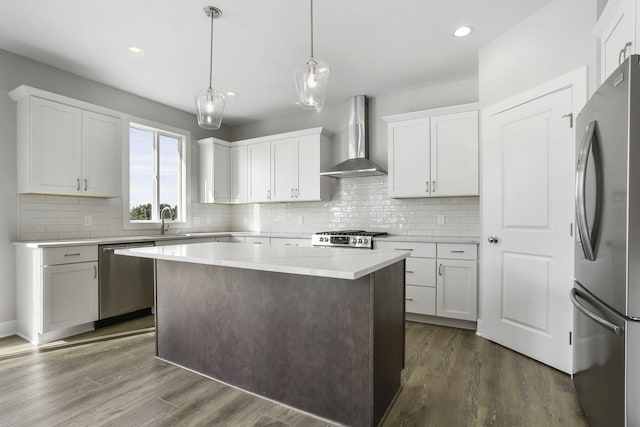 kitchen featuring white cabinets, dark hardwood / wood-style flooring, wall chimney range hood, and appliances with stainless steel finishes