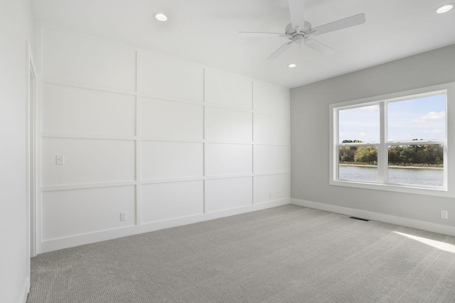 spare room featuring ceiling fan and light carpet