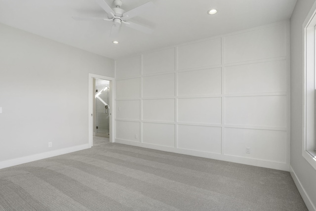 empty room with ceiling fan and light carpet