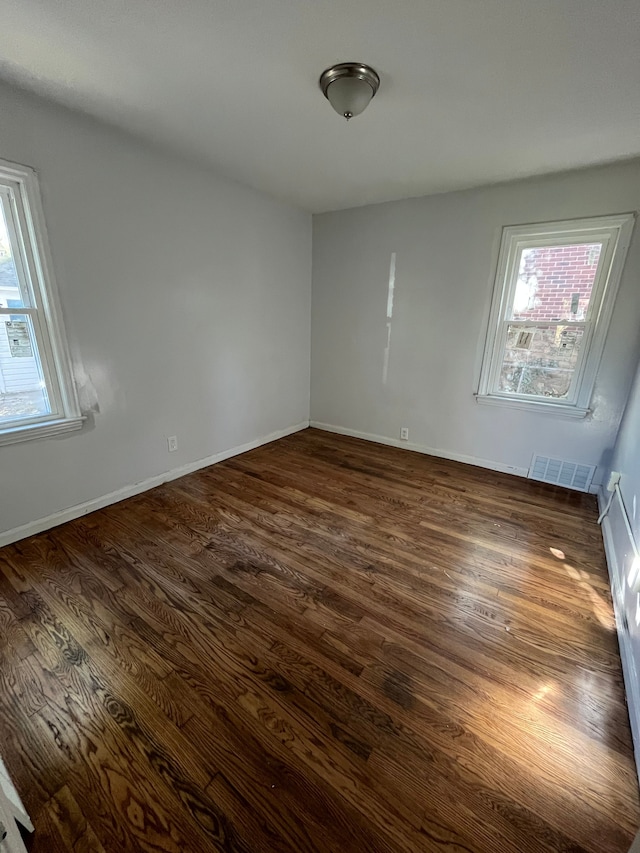 unfurnished room featuring dark hardwood / wood-style flooring