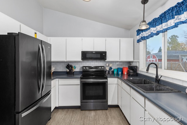 kitchen featuring backsplash, stainless steel appliances, vaulted ceiling, sink, and white cabinets