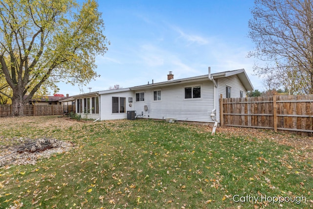 rear view of property featuring a sunroom and a yard