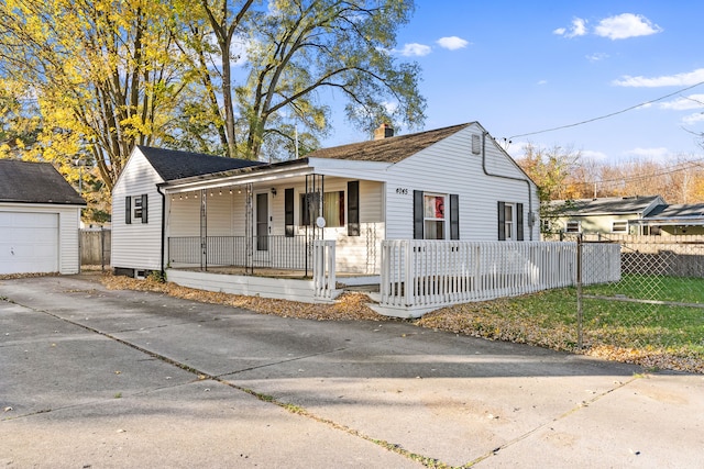 view of front of house featuring covered porch, a garage, an outdoor structure, and a front yard