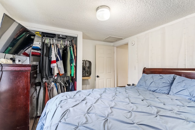 bedroom with a textured ceiling and a closet