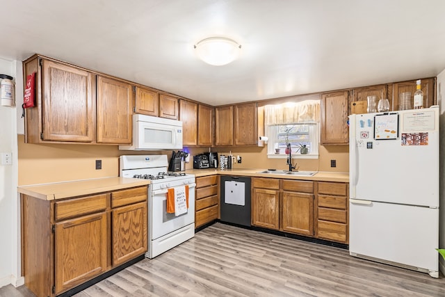 kitchen with sink, white appliances, and light hardwood / wood-style flooring