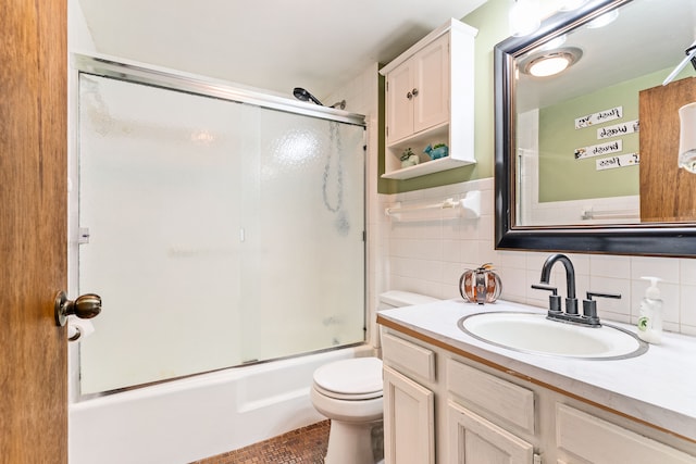 full bathroom featuring bath / shower combo with glass door, toilet, decorative backsplash, vanity, and tile walls