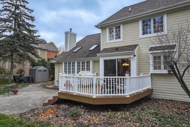 back of house featuring a patio area, a deck, and a storage unit